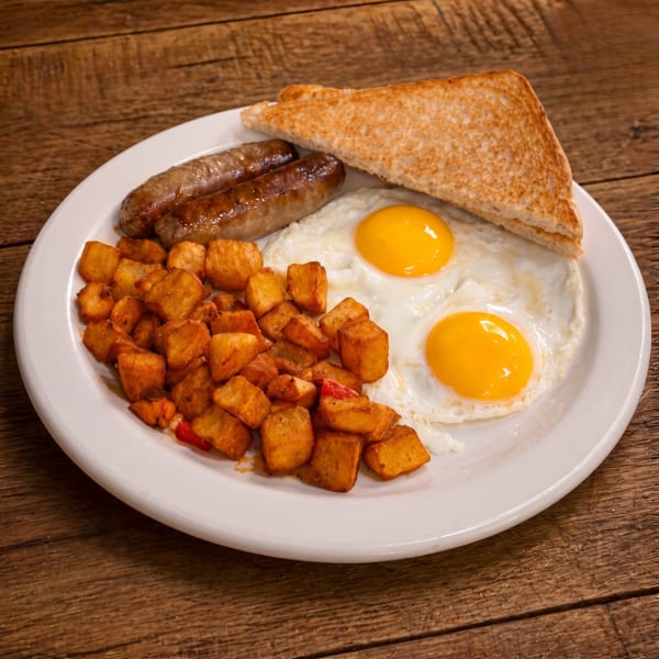 Breakfast plate with two fried eggs, two sausages, home fries, and a slice of toast.